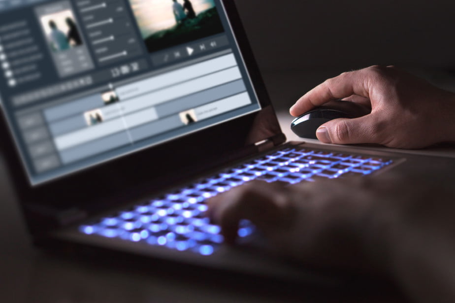 Video editor program in use, hands on laptop while working