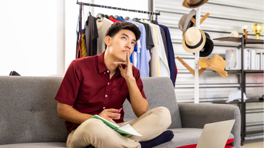 Man sitting in gray couch, thinking